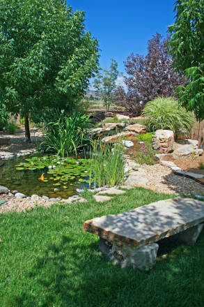 A cascading effect is created with Cinnamon Shadow Quarry boulder and Siloam slabs and a custom bench and Wall Stone borders.