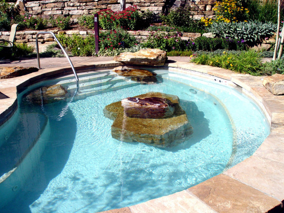 Design and Installation: Land Designs by Ellison, Avon, CO. Description: Siloam Cinnamon Shadow Quarry Boulders accents in and around pool, Siloam Custom Split Cap stone slabs around pool, and Siloam Wall slabs in background.