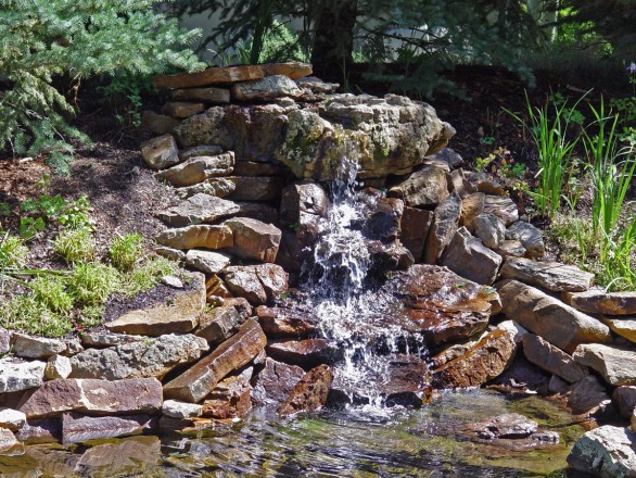 Design and Installation: Landscape Technology, Vail, CO. Description: Specimen Stone Boulder with Sienna Buff slabs and Moss Rock.