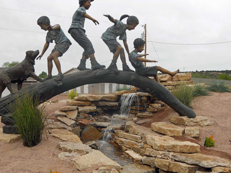 Wall Slabs and Wall Stone were used to create a waterfall feature over which a monument of children playing on a log is poised.