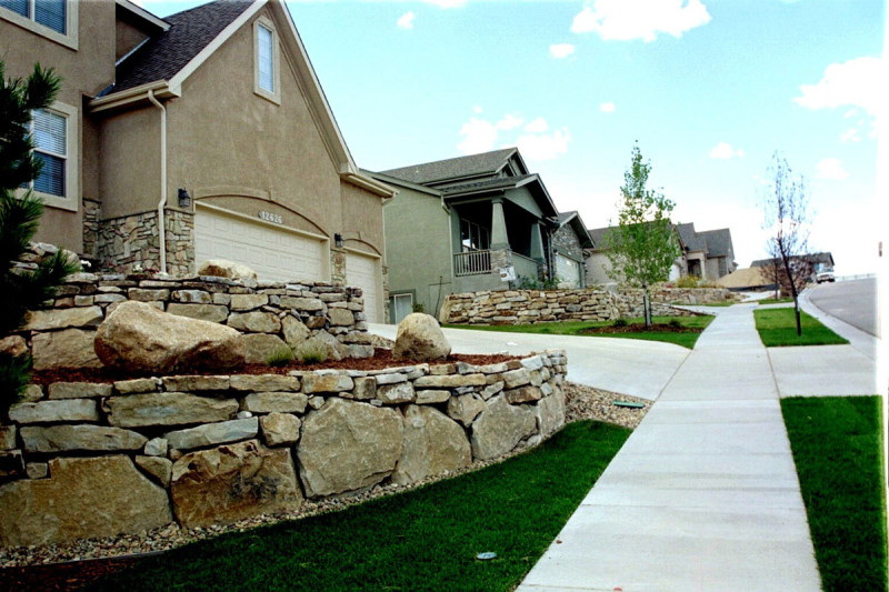 1-3 ft. diameter Cinnamon Shadow Quarry Boulders and 3-7” Wall Stone were machine and hand stack installed to create a retaining wall in the front yard of a residence in Colorado Springs, CO.